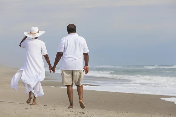 retired couple strolling beside the shore 