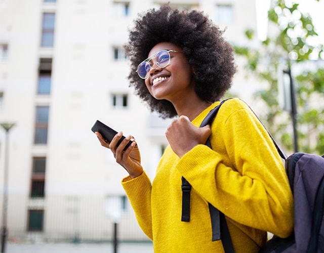Young woman speaking on the phone to her parents after sending money to them