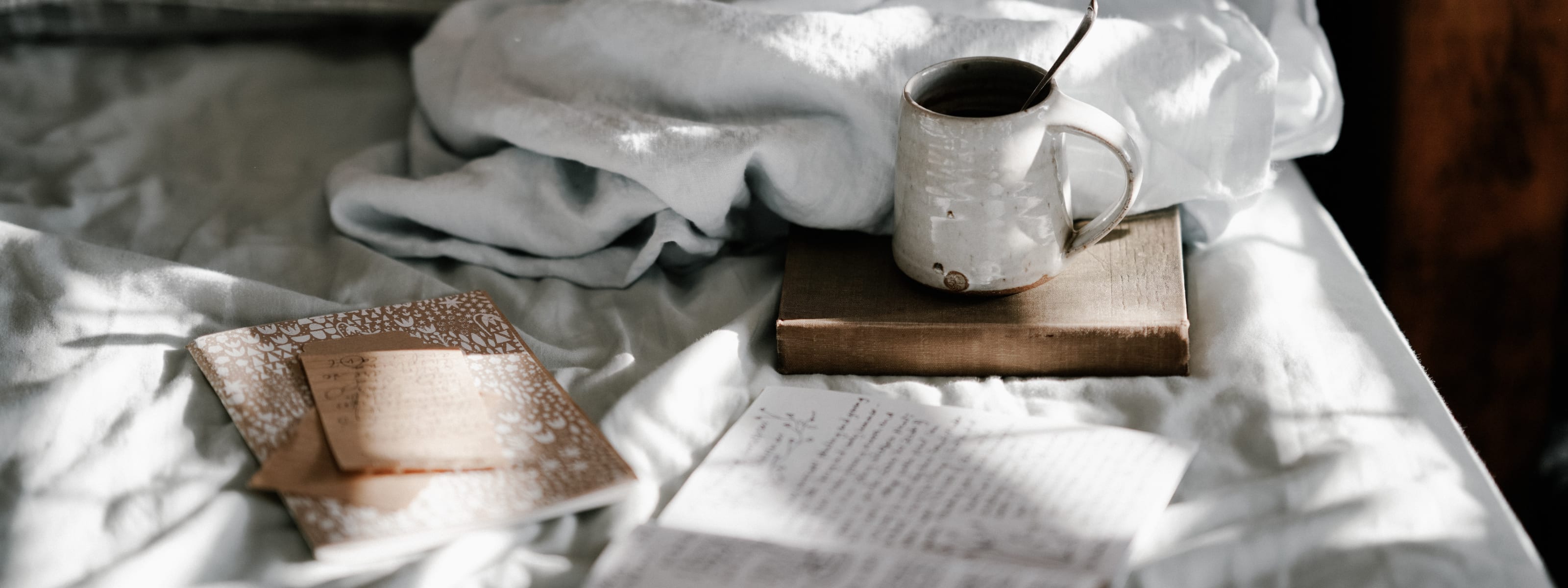 Coffee, journal, and bedsheets