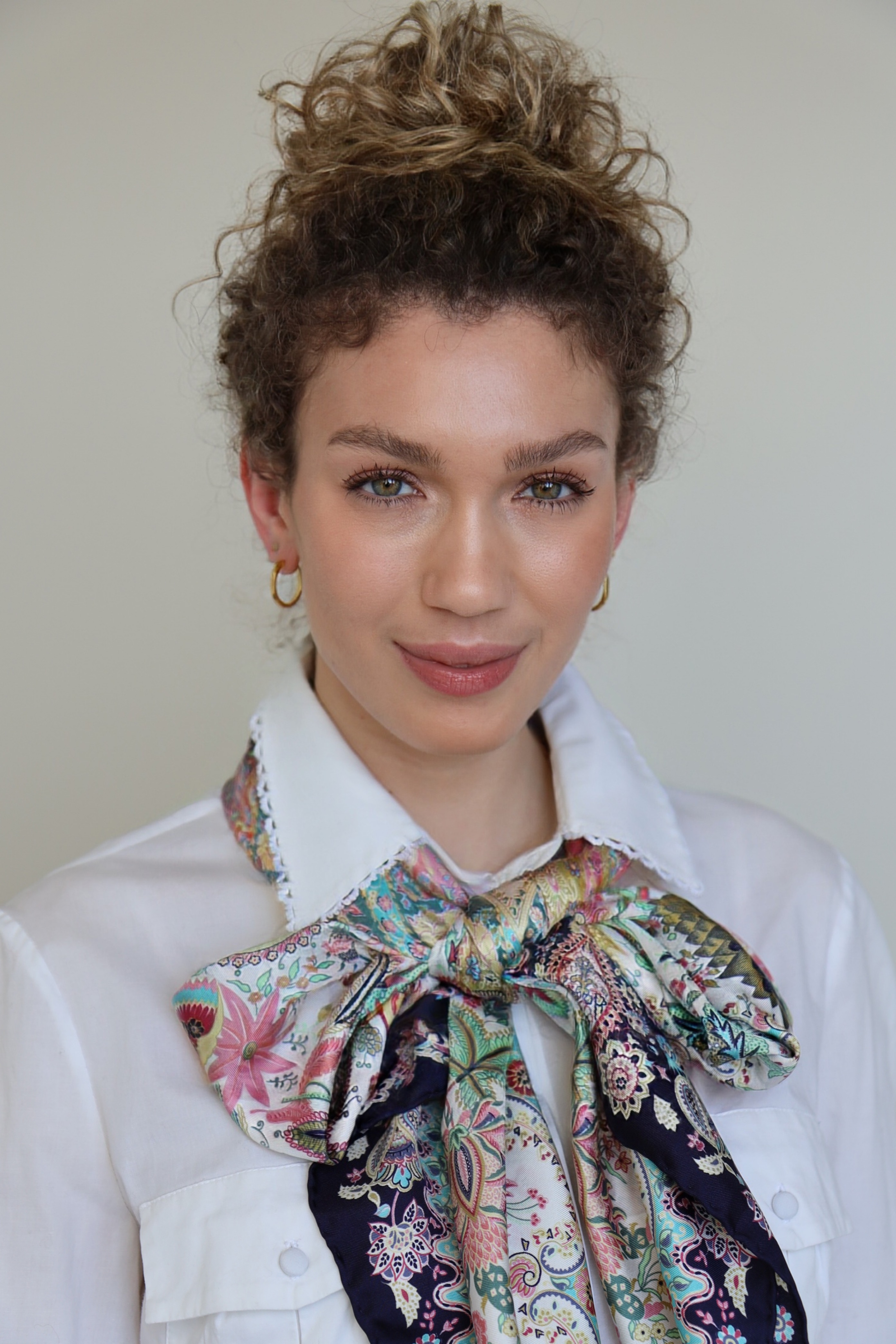 Ein Seidentuch als Schleife um den Hals gebunden verleiht jedem Look eine besonders feminine und stilvolle Note