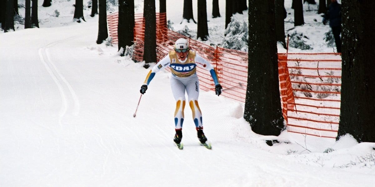 Charlotte Kalla i svensk tävlingsdräkt åker uppför en snöig skogsbacke under Tour de Ski 2008