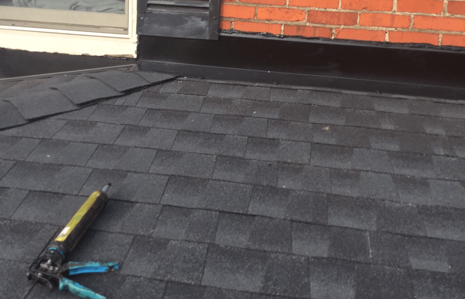 Roofsimple worker on roof installing new roofing system for Jennifer Coker