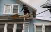 Roofsimple worker on roof installing new roofing system for Benjamin Ranieri 