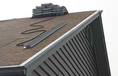 Roofsimple worker on roof installing new roofing system for David Bender