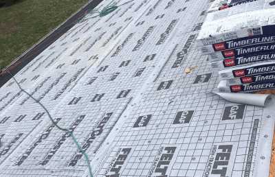 Roofsimple working on roof installing new roofing system for Claire A