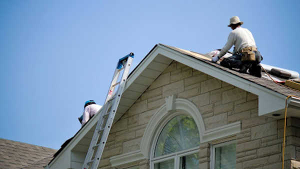 roofing contractor working on top of a roof