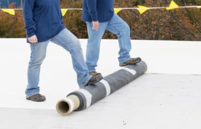 Roofers rolling our Carlisle Syntec Systems EPDM Sure-White membrane