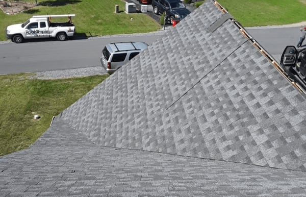 Roofsimple worker on roof installing new roofing system for M. Shankle