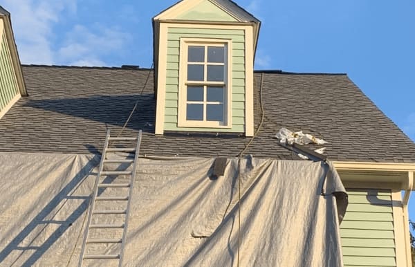 Roofsimple worker on roof installing new roofing system for Mike Yriart
