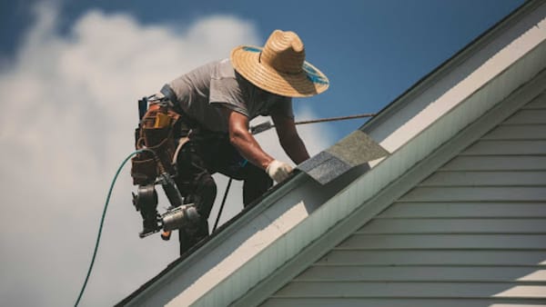 Roofer installing shingles replacement