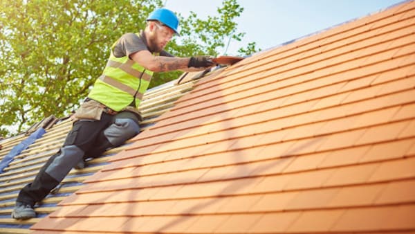 Roofer installing roofing tiles