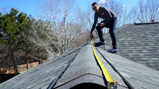 Roofer measuring a new roof installation