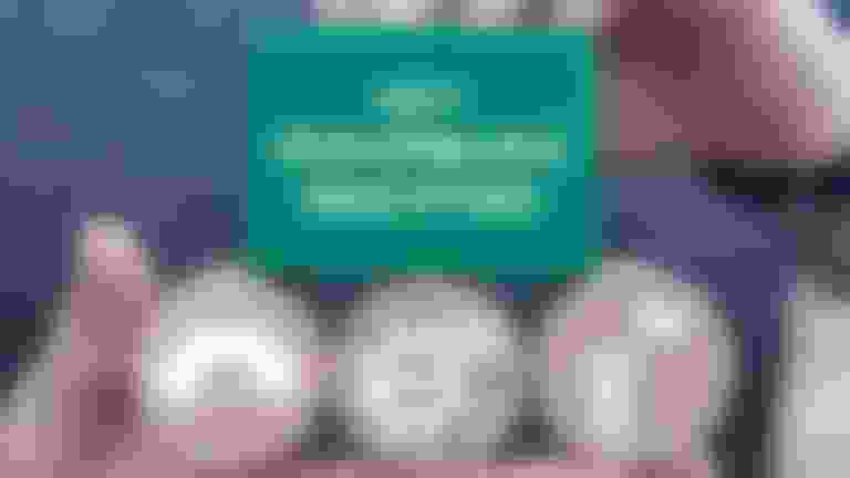 a hand three round wooden blocks and a bigger square wooden blocks with words and symbols on them.