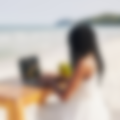 Woman on laptop at beach table