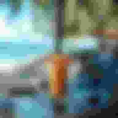 Image of tropical drink resting on a computer with a beach in the background
