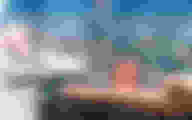 Hands holding wooden blocks and money with a city skyline in the background.