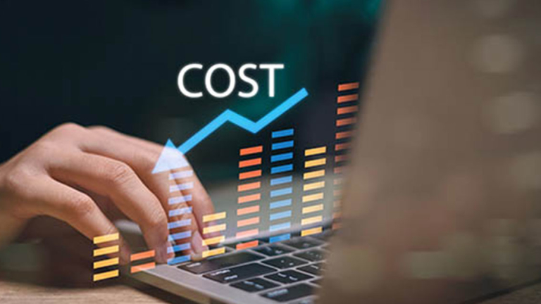 A hand on a laptop with an image of graphs and an arrow trending downward.