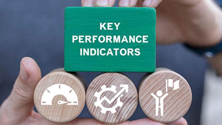 a hand three round wooden blocks and a bigger square wooden blocks with words and symbols on them.