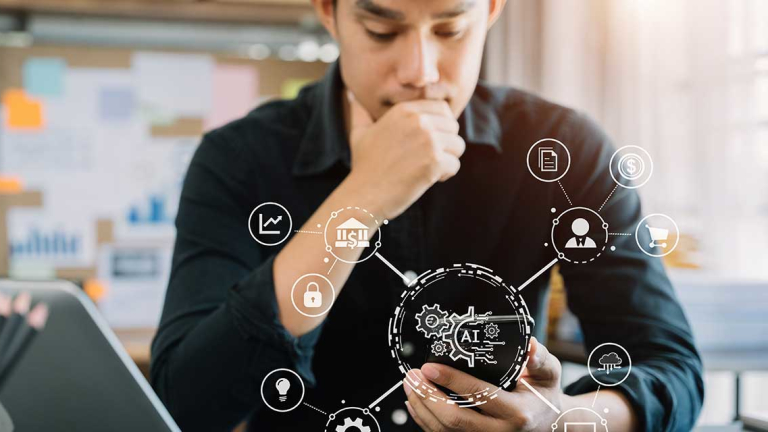 A man holding his chin, looking at his phone.
