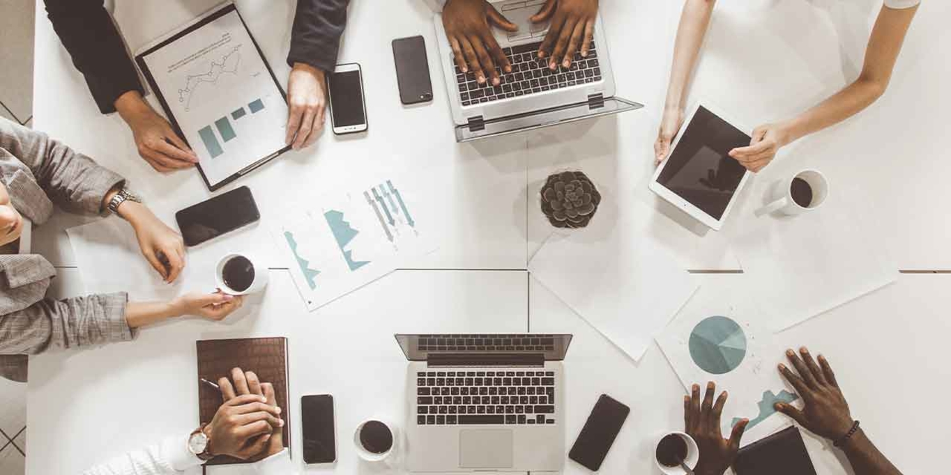 top view work workplace. A team of young office workers, businessmen with laptop working at the table, communicating together in an office. Corporate businessteam and manager in a meeting