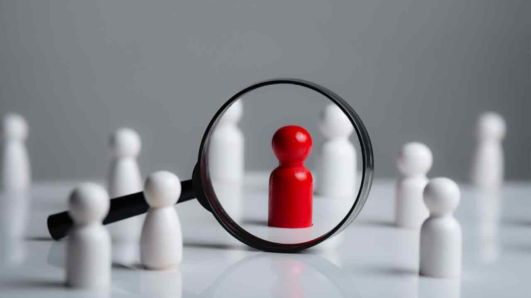 a magnifying glass looking to red wood people,Select a person in the team, Human Resource.
