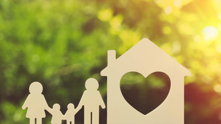 Small model of house and family on nature background