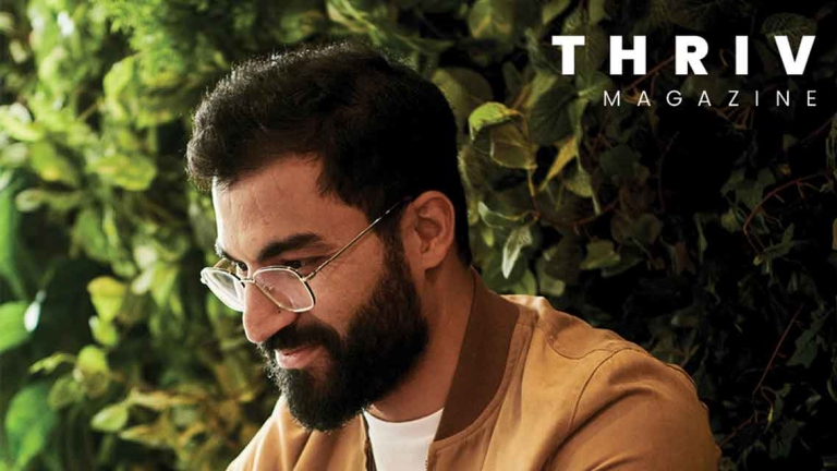 man sitting by greenery wall