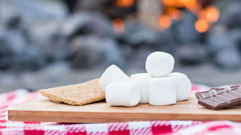 Graham cracker, marshmallows, chocolate on a cutting board.