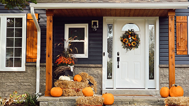 The front porch of a home decorated in a fall theme.