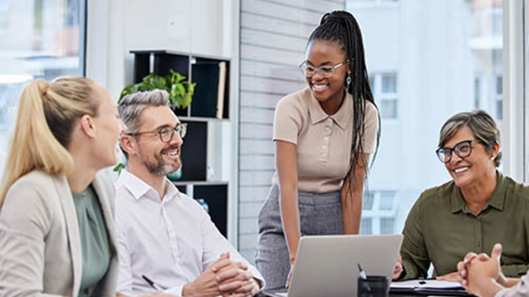 Business professionals in a meeting room, smiling.