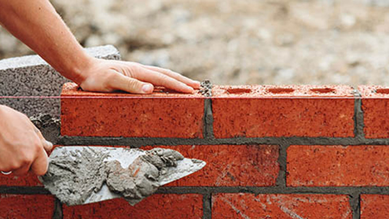 A man building a brick wall.