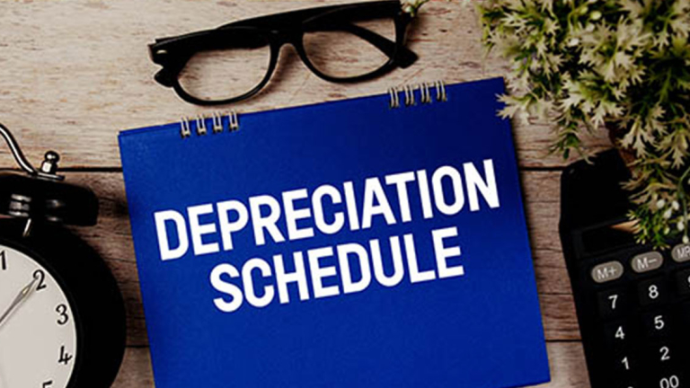 Alarm clock, glasses, calculator and notebook on a desk.