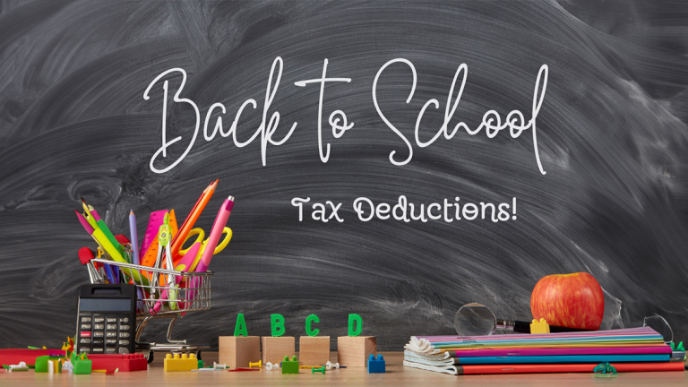 A black board and teachers desk with notebooks, a calculator and other school items.