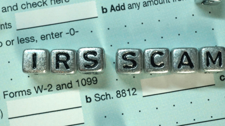 Silver cubes on a tax form that spell out IRS SCAM.