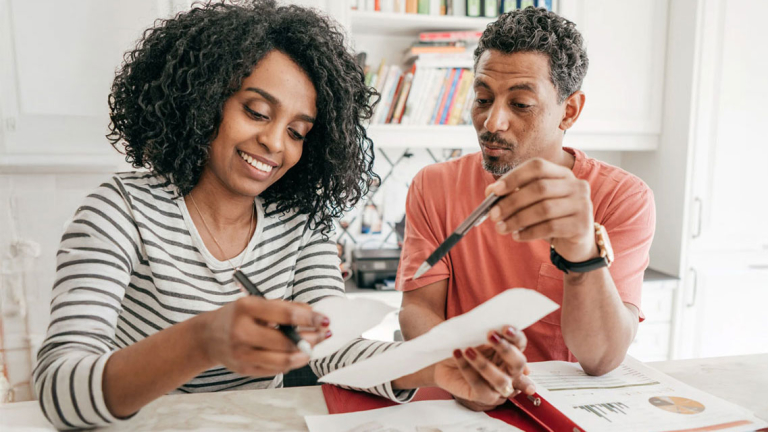 Two people at a table reviewing receipts.