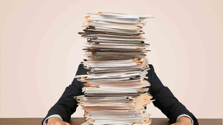 man with stack of papers