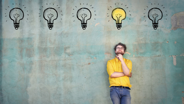 Lightbulbs painted on a wall with a man standing under them.