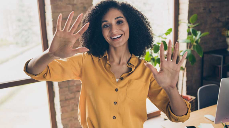A woman holding up her hands, showing all her fingers.