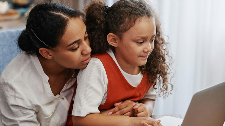 A woman and young girl using a laptop.