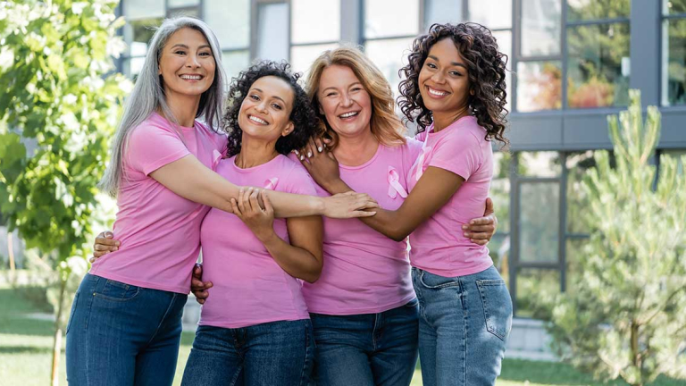Four women hugging and smiling