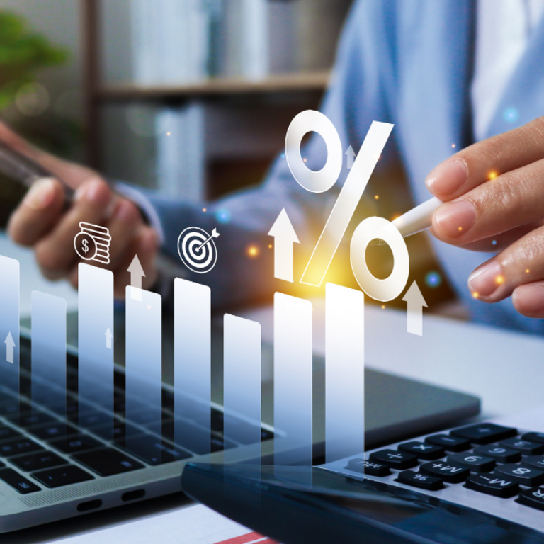 A small business owner looking at his computer and phone reviewing financial data.