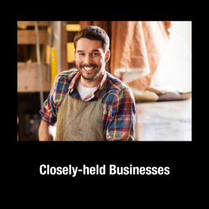 A man in an apron, in a shop, smiling