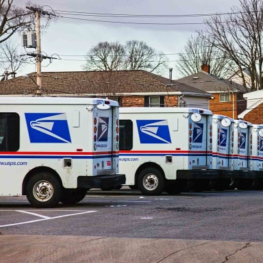 US mail trucks lined up in a parking lot