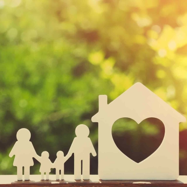 Small model of house and family on nature background