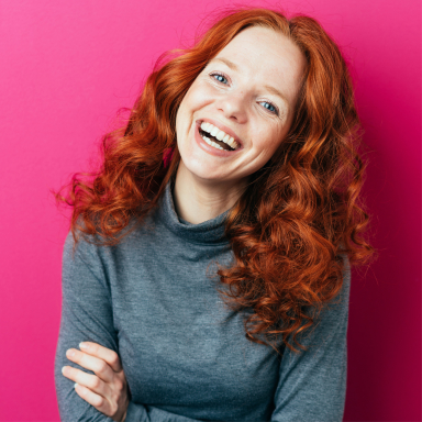 female smiling big with arms folded across her chest
