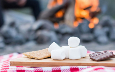 Graham cracker, marshmallows, chocolate on a cutting board.