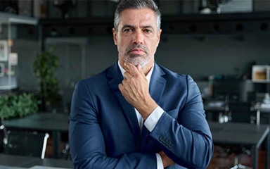 business man with hand under chin in a thoughtful pose