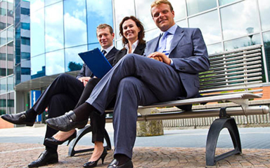 Business professionals sitting on a bench.