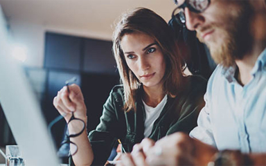 Two professionals looking at a laptop.