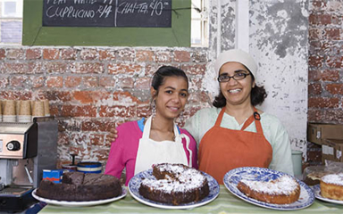 A mother and daughter working at a bakery.